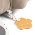 Close-up of the mustard teether attached to the Tummy Time Activity Toy Croco in sand, featuring playful dots and shapes.