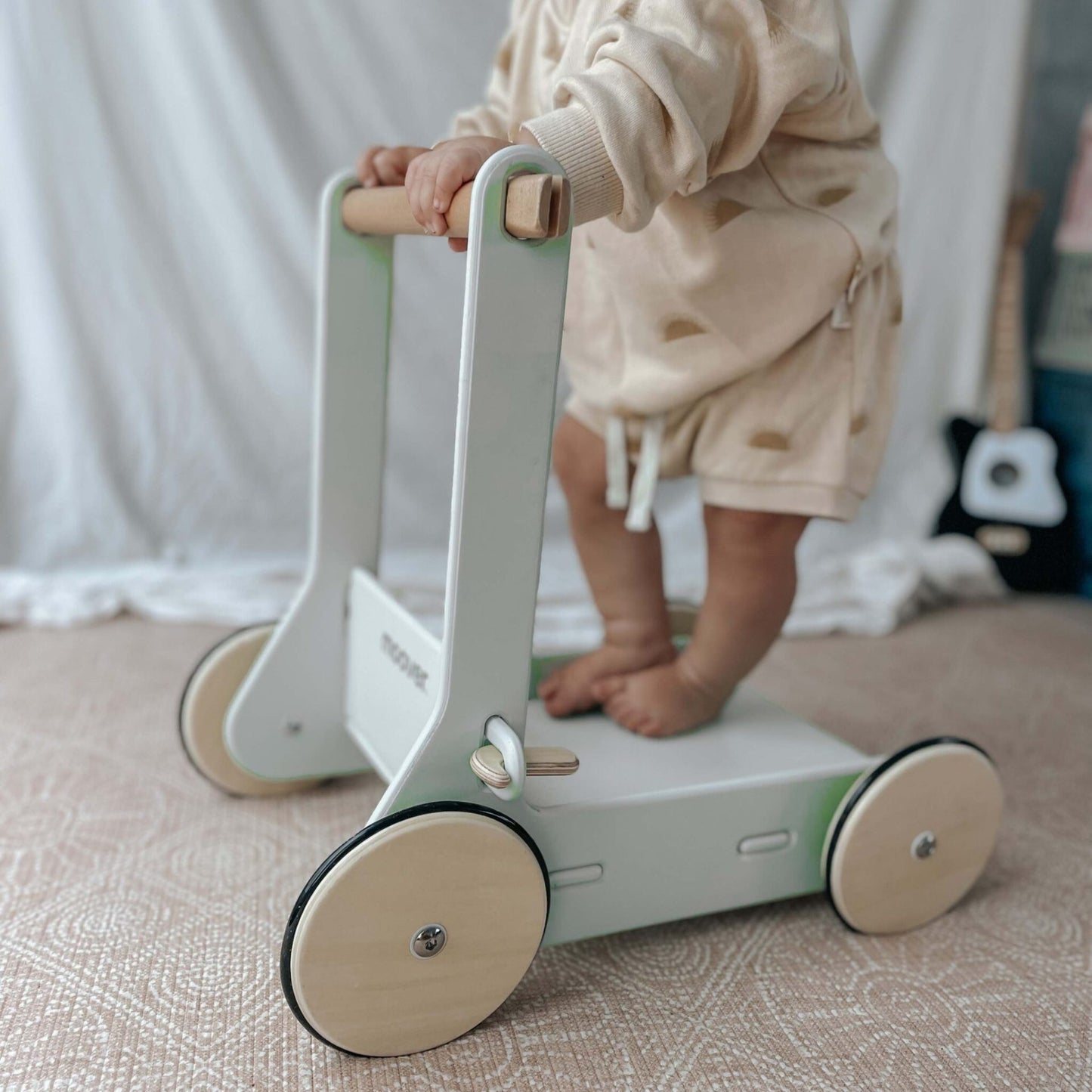 Natural and white Moover classic baby walker supporting a child taking first steps in a cozy environment.